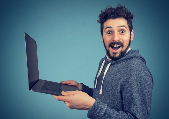 man holding a laptop looking happy